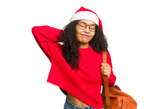 Young african american student woman wearing a christmas hat isolated touching back of head, thinking and making a choice.