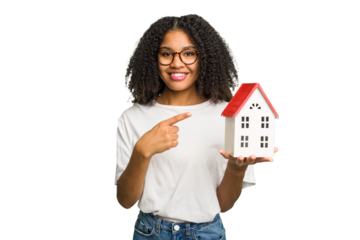 Young african american woman moving to a new home while picking up a box full of things isolated smiling and pointing aside, showing something at blank space.