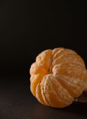 Mandarina sobre mesa de madera y fondo oscuro. Copy text. Copy space. 