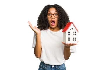 Young african american woman moving to a new home while picking up a box full of things isolated surprised and shocked.