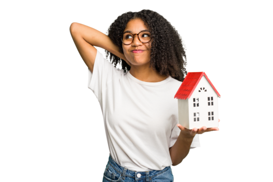 Young african american woman moving to a new home while picking up a box full of things isolated touching back of head, thinking and making a choice.