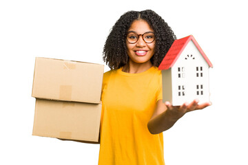 Young african american woman moving to a new home while picking up a box full of things isolated