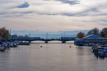 Beautiful scenic view of Limmat River, Quay Bridge, Lake Zürich and Swiss Alps seen from the old...