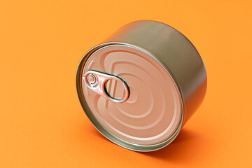 Unopened Tin Can with Blank Edge on Orange Background. Canned Food. Aluminum Can for Safe and Long Term Storage of Food. Steel Sealed Food Storage Container