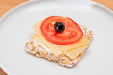 Rice Cake Sandwich with Tomato, Cheese and Olives on White Plate. Easy Breakfast. Diet Food. Quick and Healthy Sandwiches. Crispbread with Tasty Filling. Healthy Dietary Snack