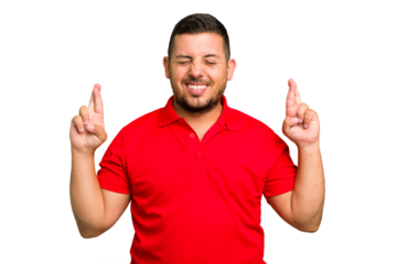 Young caucasian man isolated crossing fingers for having luck
