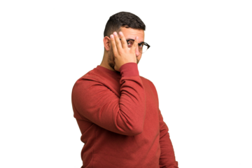 Young caucasian man isolated blink at the camera through fingers, embarrassed covering face.