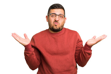 Young caucasian man isolated doubting and shrugging shoulders in questioning gesture.