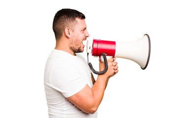 Young caucasian man holding a megaphone isolated