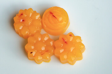 Close up shot of four vegan orange and saffron flower shaped agar jellies
