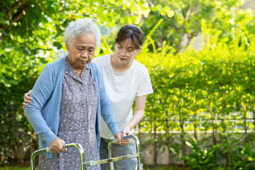 Caregiver help and care Asian senior or elderly old lady woman use walker with strong health while...