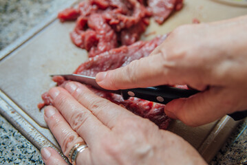 Mulher cortando carne de boi