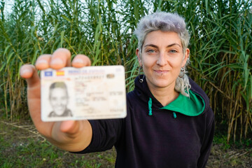non-binary person looking at camera with ID in hand. non-binary identity. Trans law
