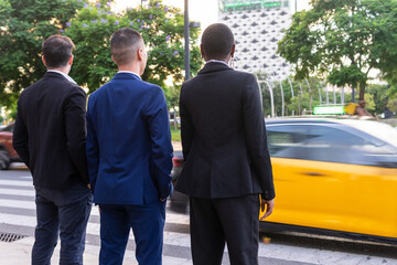 Anonymous multiethnic colleagues standing near road