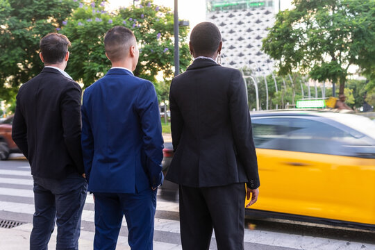 Anonymous multiethnic colleagues standing near road