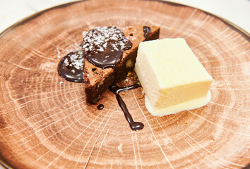 Chocolate brownie dessert with vanilla ice cream on imitation wood plate