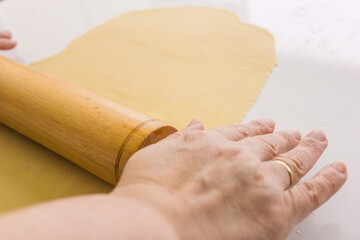 roll out the pasta dough, old woman roll out dumpling dough with a wooden rolling pin