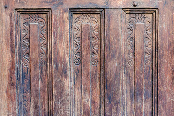 Close up to an old weathered wood door with rustic model or design