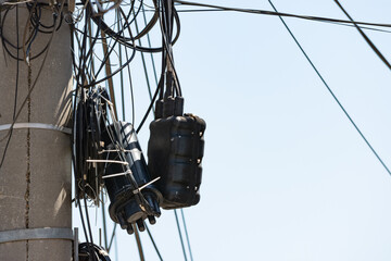 Tangle cables on lamppost pole connected to splice or branch box. Fiber optics mixed up with other...