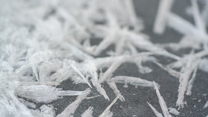 Ice and snow crystals forming spike shapes on frozen river, closeup macro detail, abstract winter background