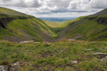 Fototapeta na wymiar Dramatic view from the edge of High Cup Nick down the High Cup Gill chasm, Eden Valley, North Pennines, Cumbria, UK