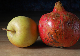 pomegranate and apple on a wooden background