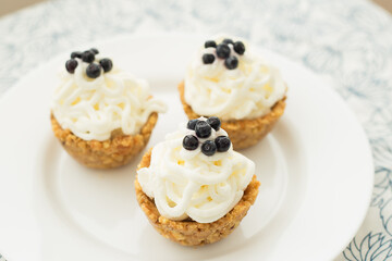 Homemade muffins with blueberries, cream and fresh berries on a napkin