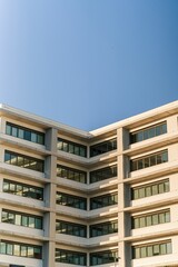 Vertical view of a residential corner building's exterior under the blue sky