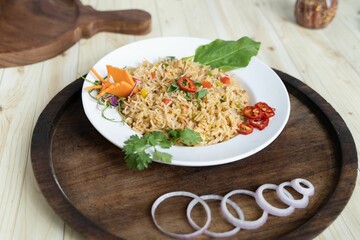 White plate with delicious cooked white rices with groceries on a wooden table