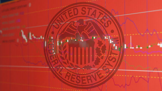 Seal of the Federal Reserve System on charts red screen of stocks exchange. FED seal hover graphic candles of the NASDAQ or the S&P.
