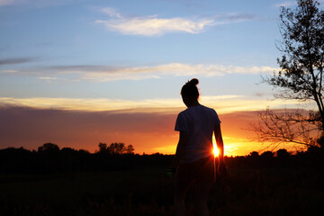 A teenage girl in the rays of the setting sun
