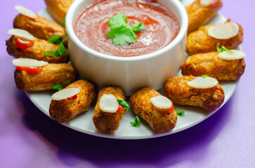 Halloween bloody fingers, pork cocktail sausages decorated with flaked almonds served with tomato and pepper dip