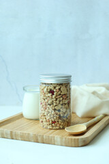 granola Musli in a jar on table against white wall 
