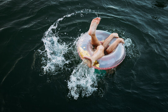 Kid's limbs sticking out of swim float in lake