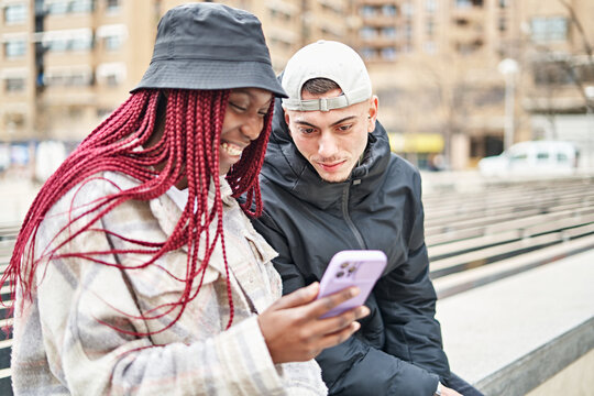 Portrait of a multi-ethnic couple using the phone, in the street