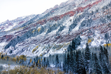 Maroon Bells red mountains in Aspen, Colorado covered in snow after winter storm froze in October late autumn fall in change of seasons in dark morning