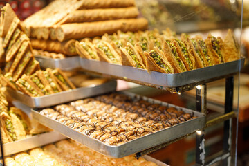 Traditional Turkish dessert Baklava close-up in the local Baklava shop, Turkey. Trays of delicious baklava displayed in showcase of baklavalari cafe