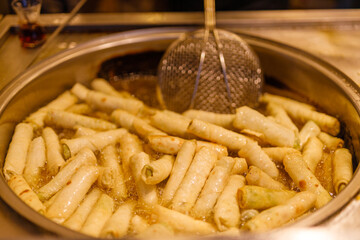 Turkish Dessert Churros Halka Tatli frying in hot oil. Turkish doughnuts or traditional ring sweet - Halka Tatli, kerhane tatlisi.