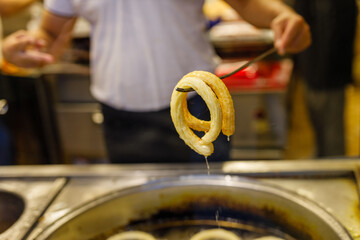 Turkish Dessert Churros Halka Tatli frying in hot oil. Turkish doughnuts or traditional ring sweet - Halka Tatli, kerhane tatlisi.