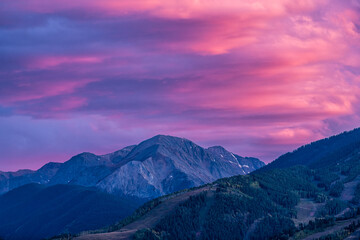 Pink purple colorful sunset in Aspen, Colorado with Rocky mountains of Buttermilk ski slope...