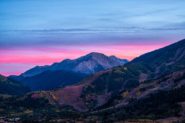 Fototapeta na wymiar Pink purple sunset in Aspen, Colorado with Rocky mountains of Buttermilk ski slope mountain in autumn fall with pastel color twilight sunset or dusk