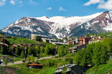 Mount Crested Butte small ski town city resort in summer with colorful grass and wooden lodging...