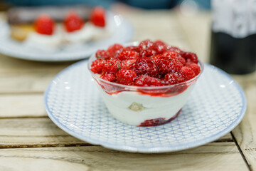 Chocolate mousse with whipped cream and fresh raspberries in a glass in caffee