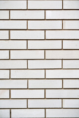 Vertical photo of a white brick wall