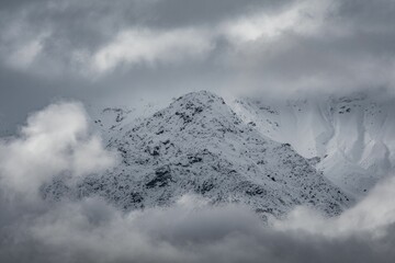 Landscape of snowy mountain under sunny blue sky, grayscale shot