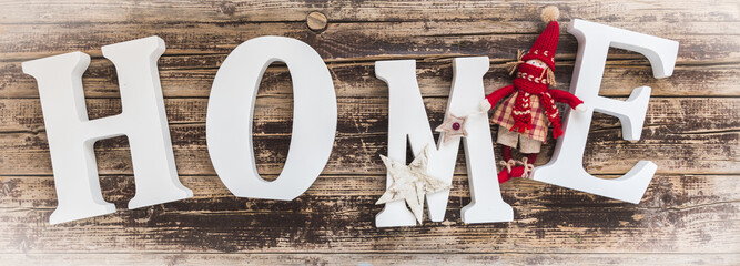 Home - white letters with small christmas decoration on old wood