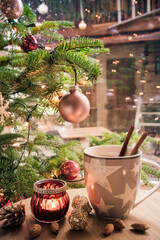 Cup of tea on a coffee table next to a Christmas tree, harmonious afternoon Christmas scene,...