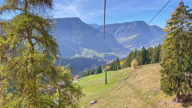 Travel video Seceda ropeway in Dolomites with Autumn Leaves background A wonderful view of Seceda mountains, dolomites, italy, Cable Car moving down the mountain with beautyful view in sunny day