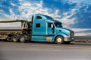 Fototapeta na wymiar American truck with tipper semi-trailer moves along road.