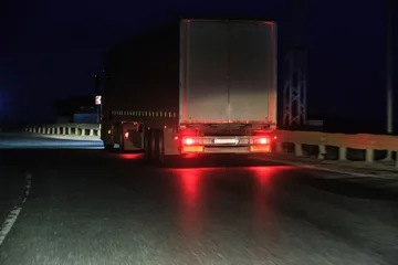 Afwasbaar Fotobehang Snelweg bij nacht Truck Moves at Night on a country road